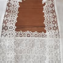 Dentelle blanche plissée, motifs floraux, en cours de pose